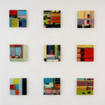 Nine colorful abstract paintings by Barry Ginder in a three-by-three grid are displayed on a white wall, each featuring geometric shapes and varied color blocks.