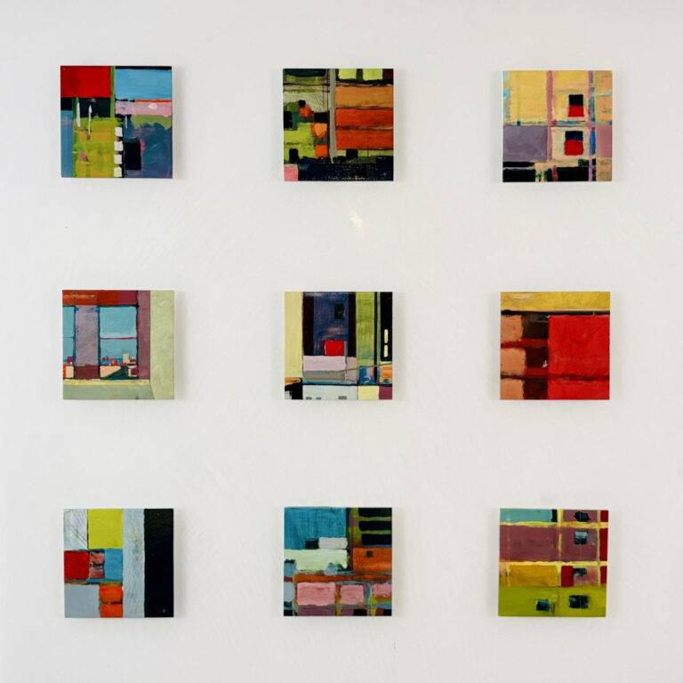 Nine colorful abstract paintings by Barry Ginder in a three-by-three grid are displayed on a white wall, each featuring geometric shapes and varied color blocks.